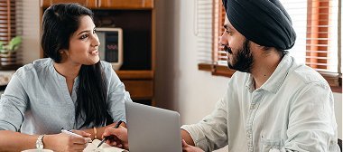 Two colleagues reviewing a laptop together