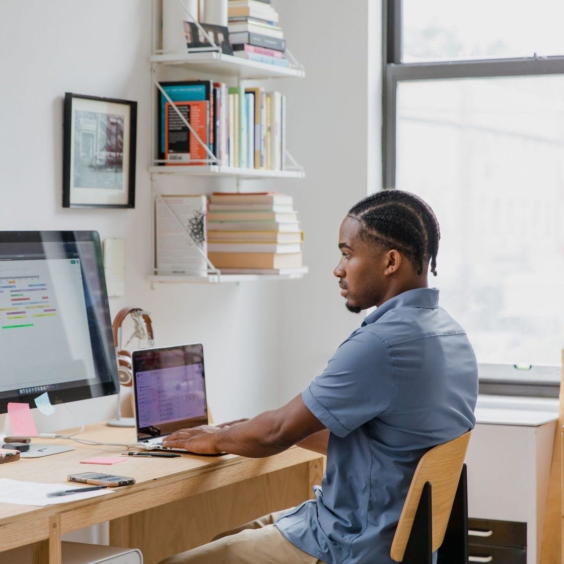 A buyer working across two screens at his desk, with the ERP open on one of them