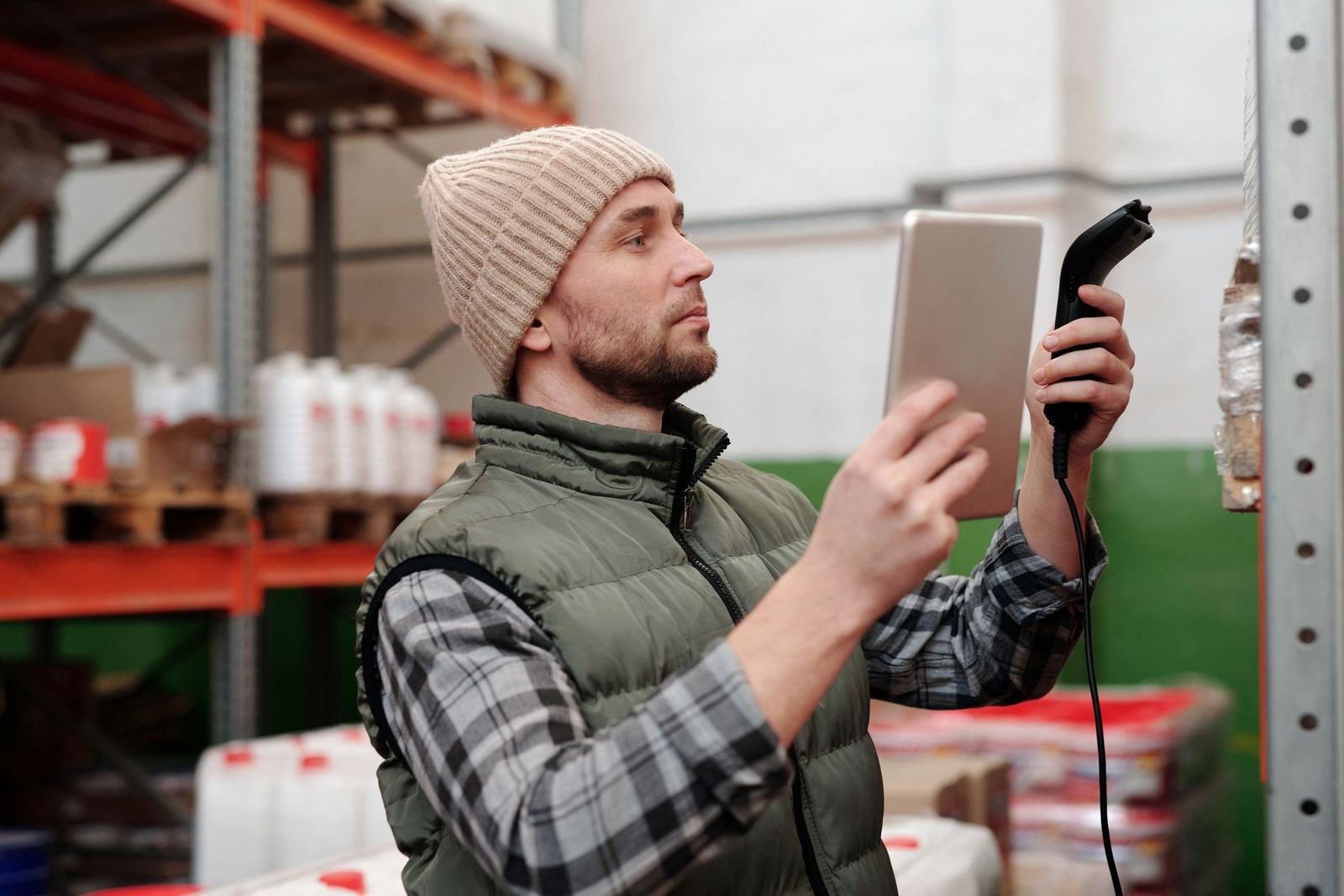 A warehouse worker checks stock on a tablet, the kind of supplier work a Master Vendor manages for you