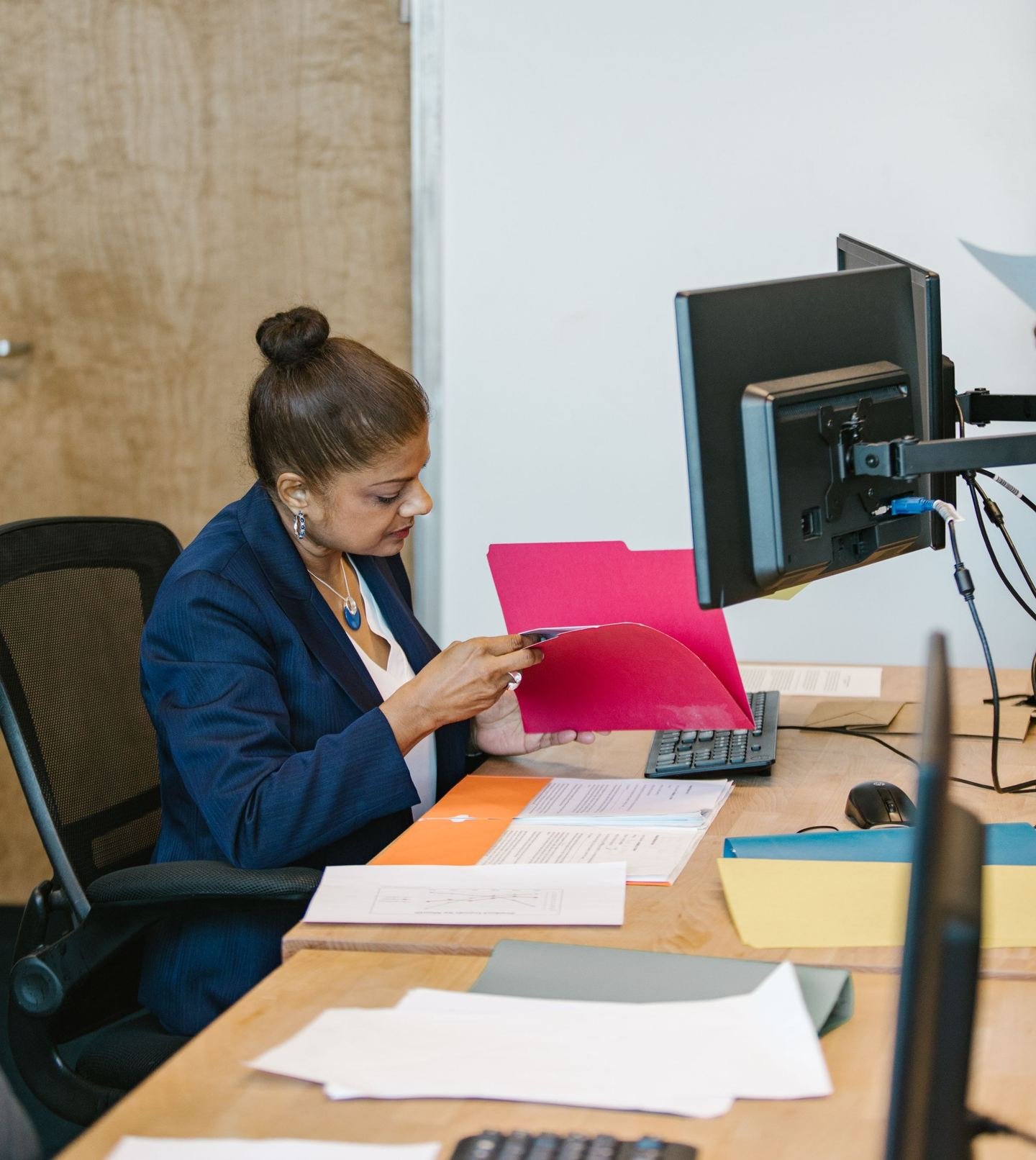 Procurement professional reviewing documents at her desk